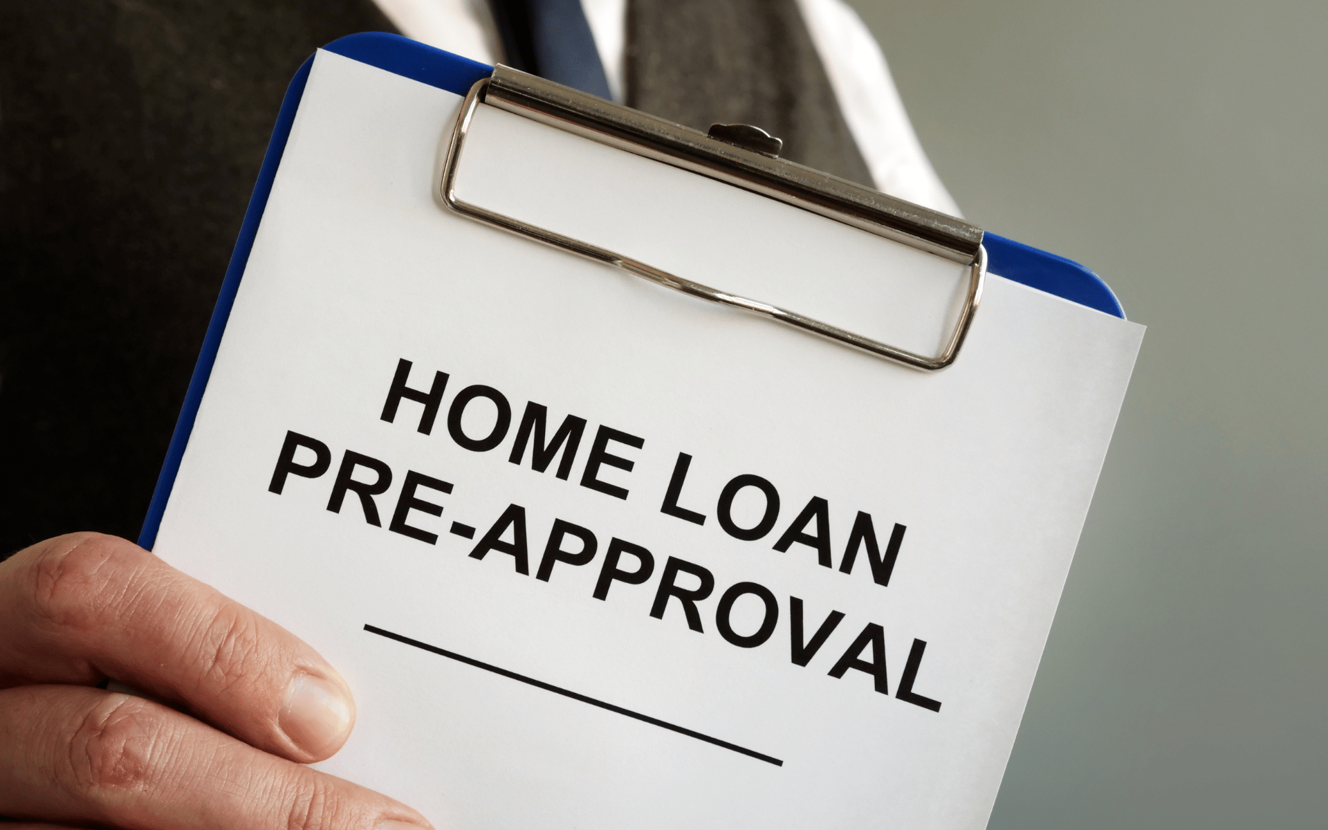 Clipboard labeled “HOME LOAN PRE-APPROVAL” held in one hand.