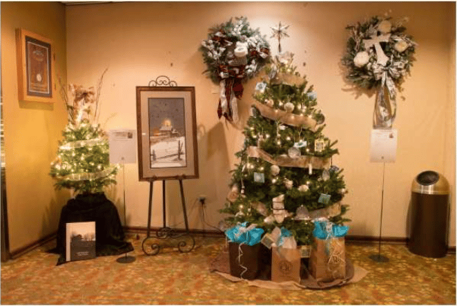 Decorated Christmas trees and wreaths displayed indoors, with gifts beneath the largest tree.