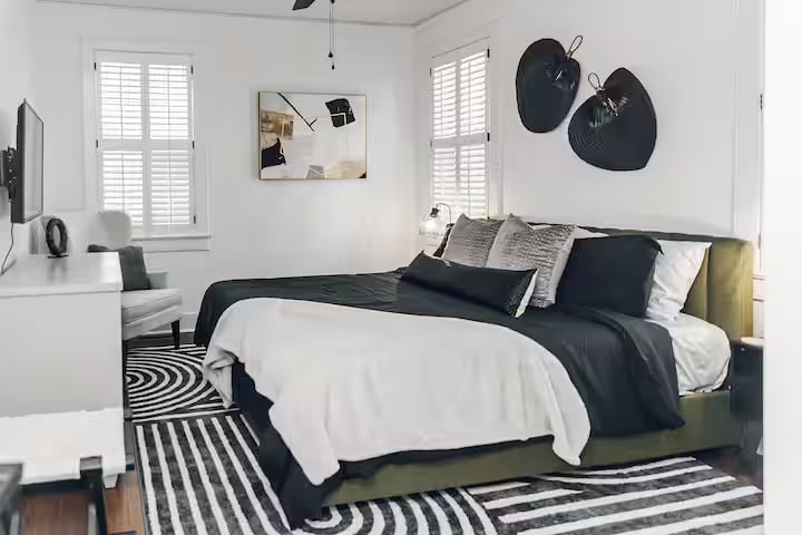 Primary bedroom with hardwood floors and neutral paint in main house.