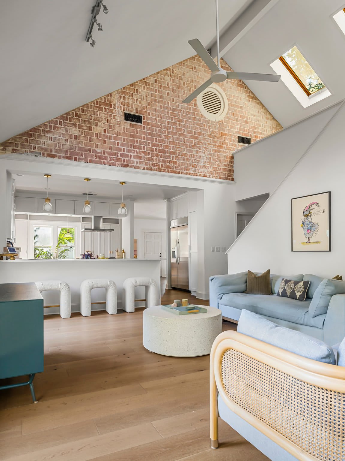 Two-story family room with brick accent wall and vaulted ceiling at 1500 Northwood Rd, Pemberton Heights, Austin. Renovation by McWalters Collaborative.