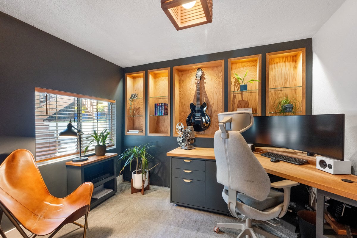 Modern home office with built-in shelving, desk workspace, and guitar display in a stylish San Francisco home.