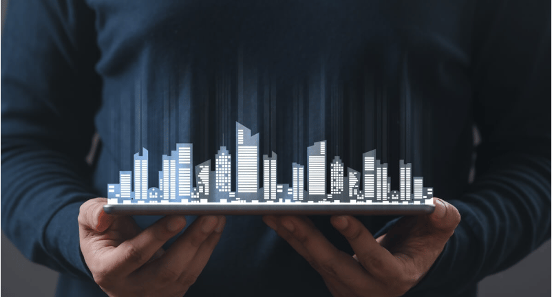Person holding a tablet displaying a digital city skyline.