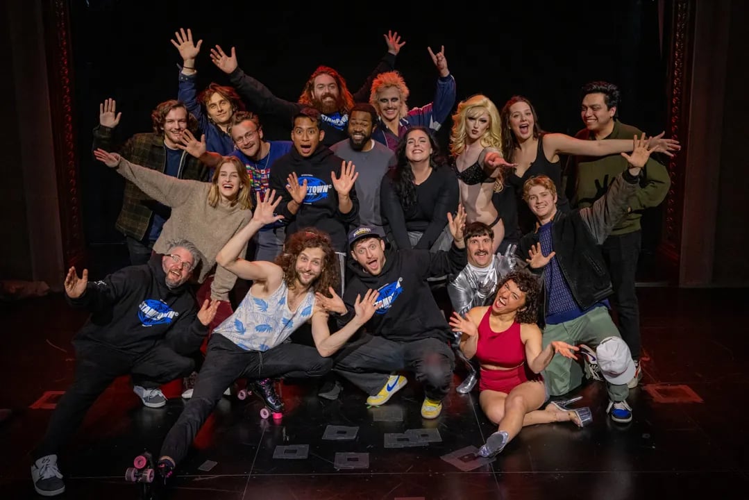 Cast of the comedy variety show "Stamptown" posing on stage at SF Sketchfest, with members wearing branded hoodies and costumes.