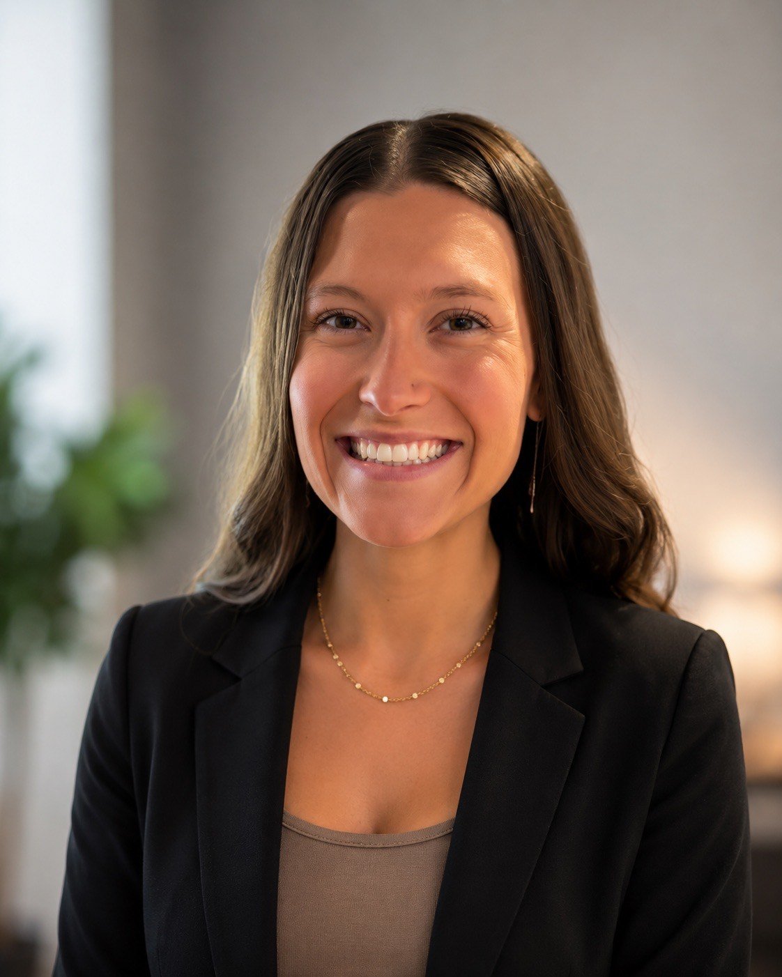 Hannah Ganley smiling in a black blazer and gold necklace.