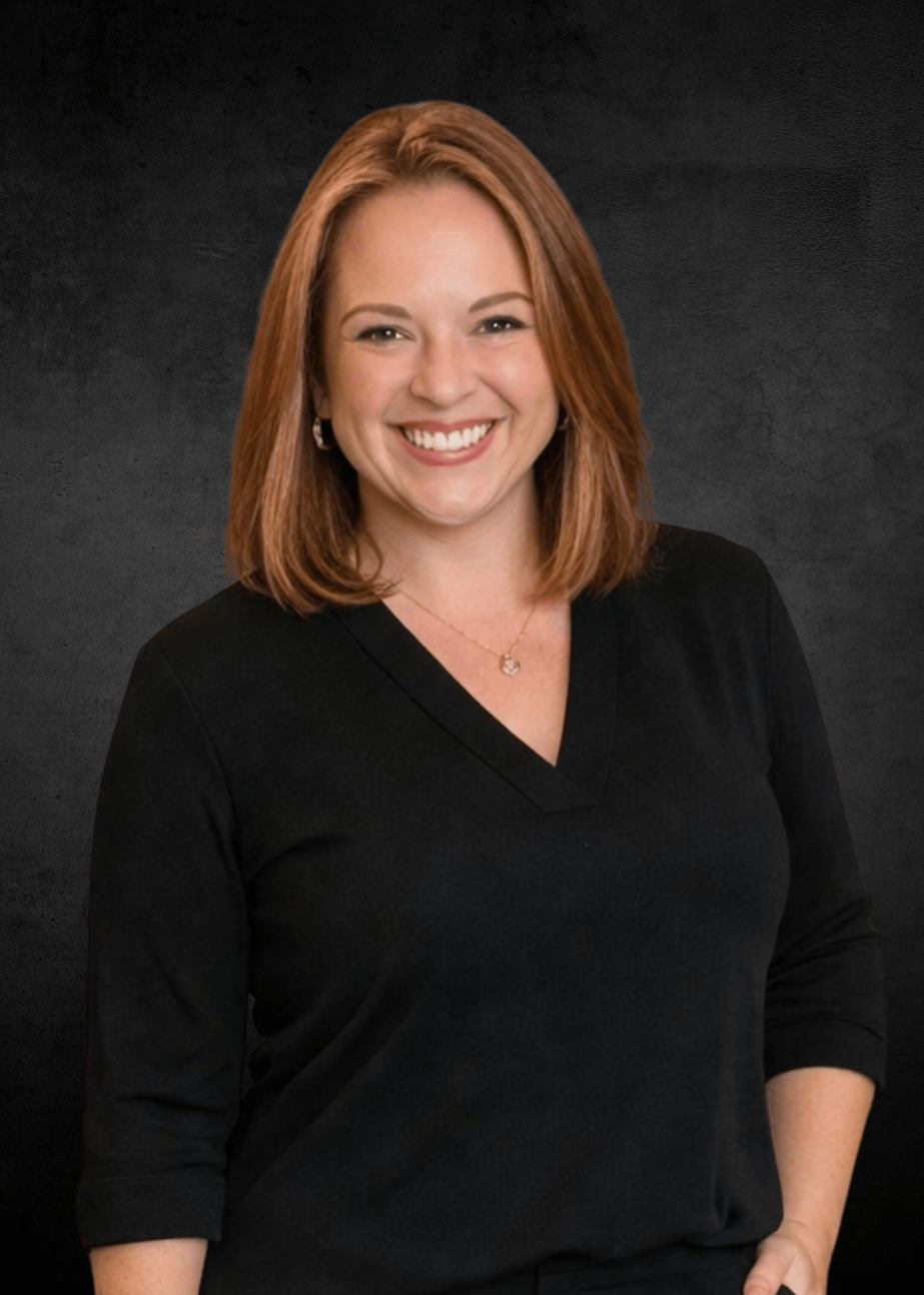 Angela Hissam smiling, with shoulder-length auburn hair and a black top.