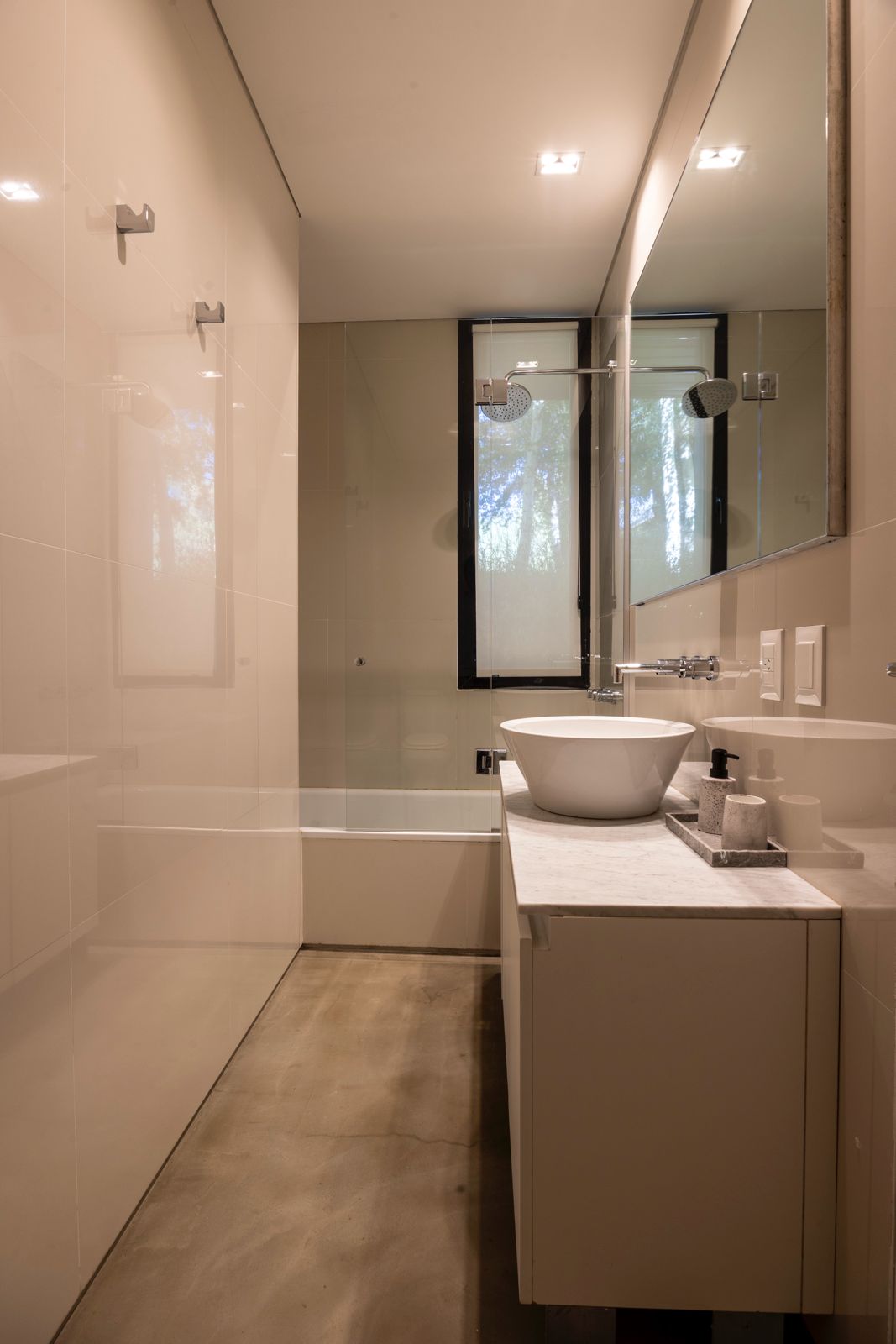 Modern bathroom with a glass shower, freestanding vessel sink, and marble vanity.