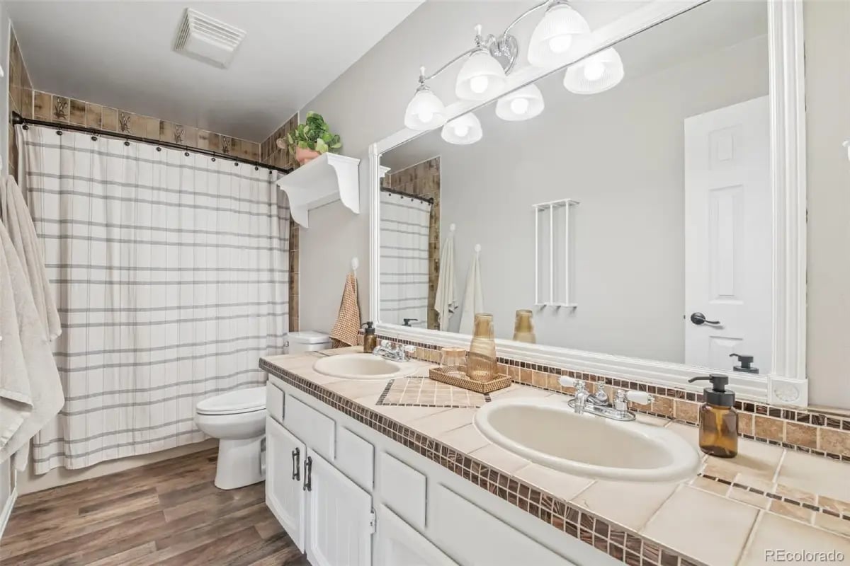 Full bathroom featuring a tiled double vanity and a large mirror at 278 Overlook Drive.