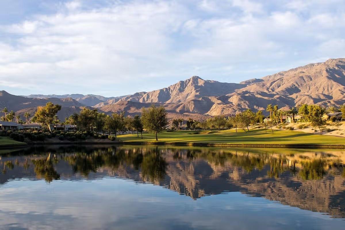 Golf course and lake with mountain views near Coral Mountain in La Quinta, California.