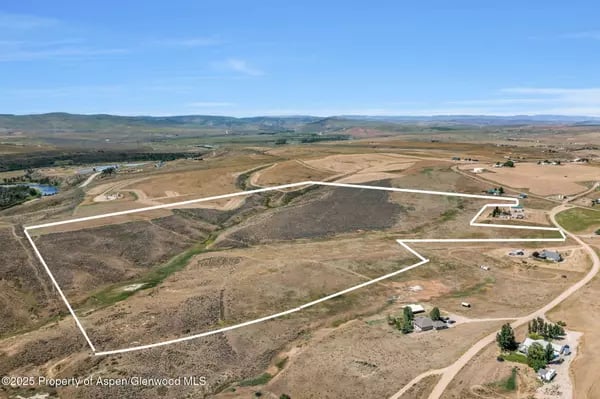 Aerial view of a large outlined rural parcel near Craig, with dirt roads and distant hills.