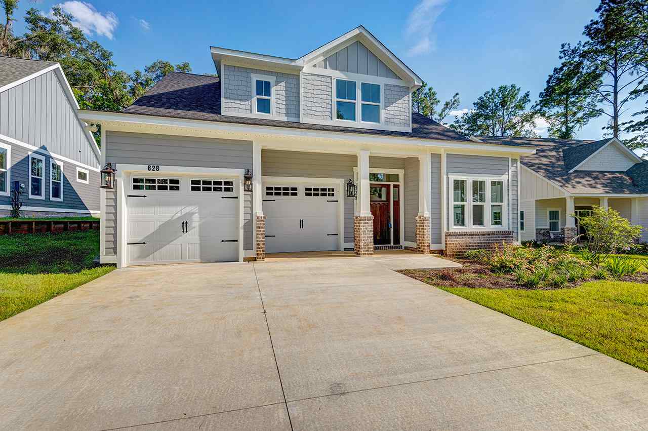 A residential property featuring two garages and a spacious driveway.