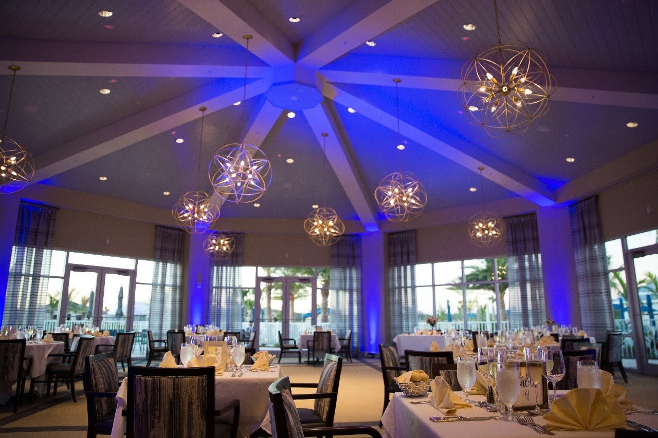 Upscale dining room at Greyhawk clubhouse with modern chandeliers and full table settings in Naples Florida