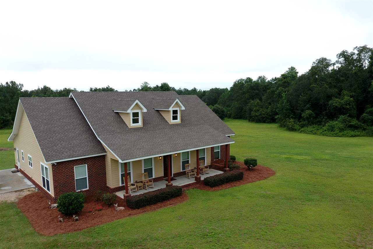 A spacious house surrounded by a vast yard and an expansive driveway, showcasing a welcoming and open environment.