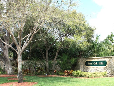 Royal Oak Hills entrance sign among mature trees and landscaped greenery.