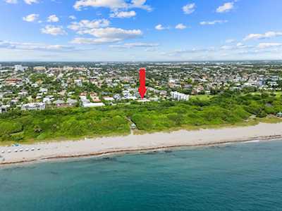 Aerial view of East Boca coastline, with a sandy beach, ocean, and red location arrow.