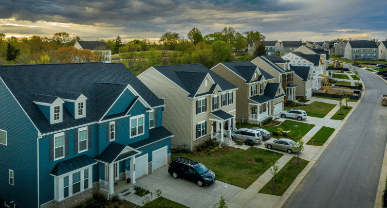 Aerial view of newer two-story homes lining a curving neighborhood street.