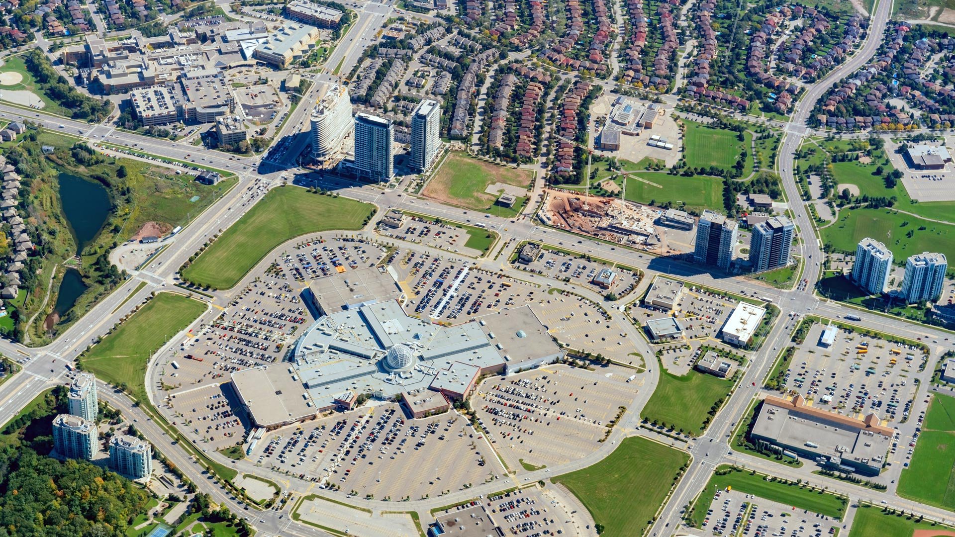 An aerial view of modern detached family homes, parks, and tree-lined streets in North Mississauga, highlighting real estate in Churchill Meadows, Meadowvale, and East Credit.