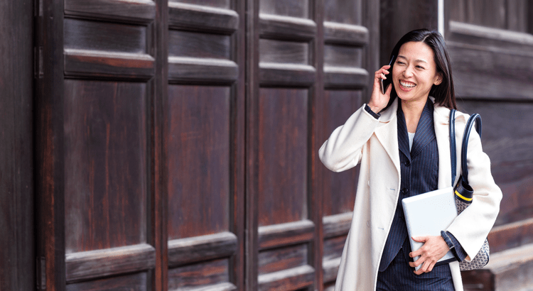 A professional woman in a suit and coat engaged in a conversation on her cell phone.A professional woman in a suit and coat engaged in a conversation on her cell phone.