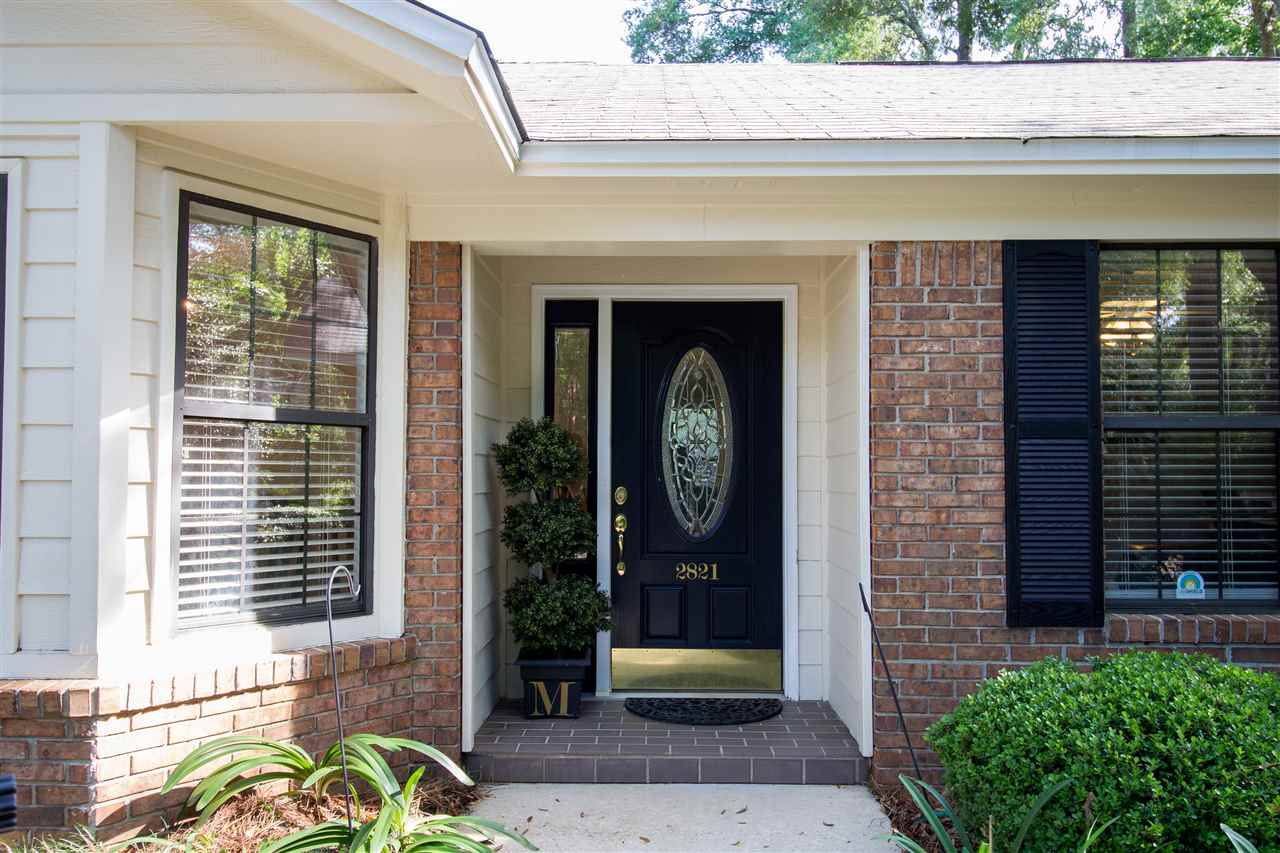 A brick house featuring a black door and window, showcasing a classic and inviting architectural style.