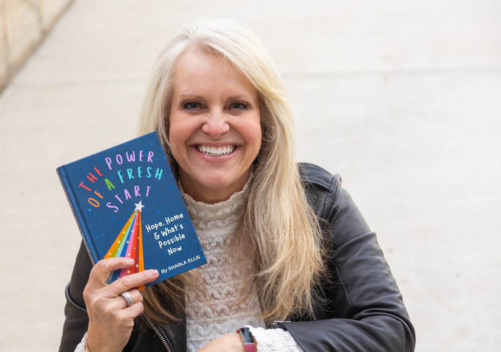 “Sharla Ellis Utah mortgage expert holding a book titled ‘The Power of a Fresh Start’ symbolizing a new chapter for multigenerational homebuyers.”