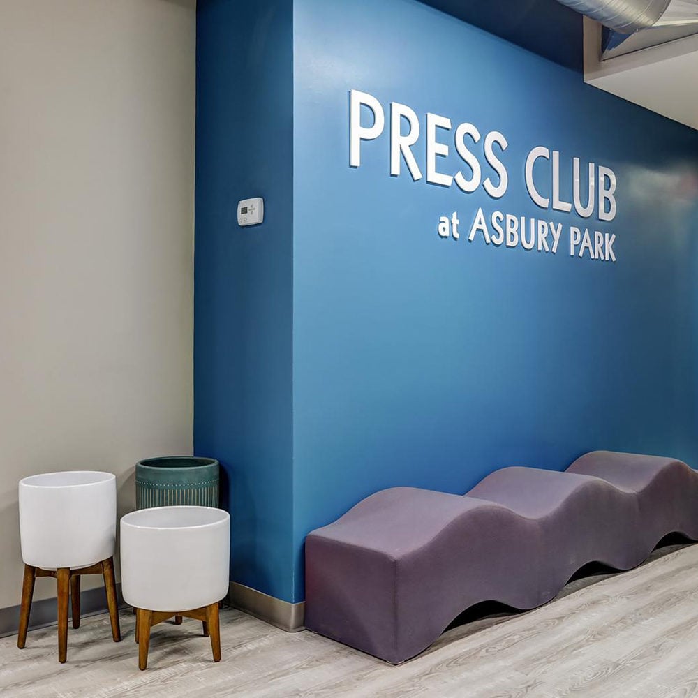 Press Club at Asbury Park lounge with a blue sign wall and sculptural purple bench.