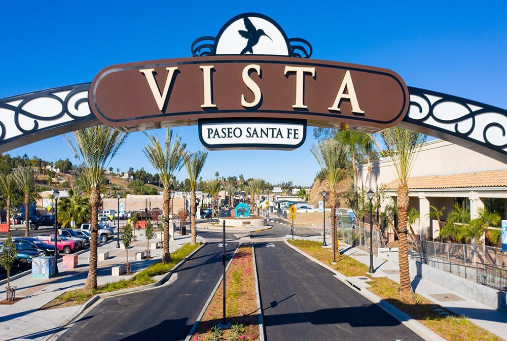 Vista’s Paseo Santa Fe entrance arch above a palm-lined street.