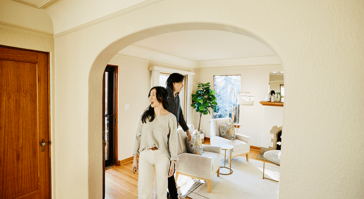 A woman and a man standing together in a doorway, engaged in conversation or sharing a moment.