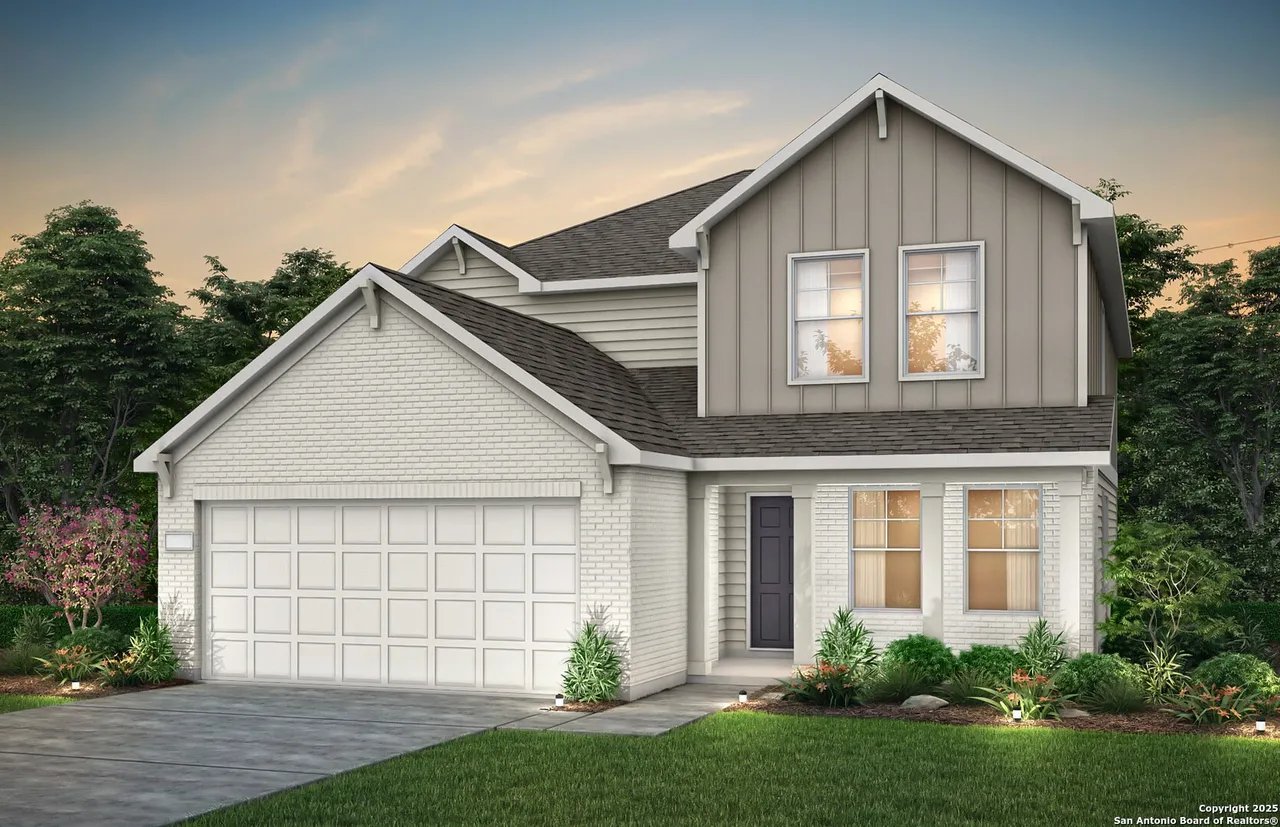 Two-story white brick home with gray siding, attached garage, and landscaped front yard.