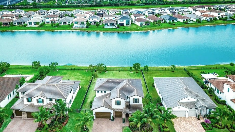 Aerial view of lakefront homes lining a blue lake.