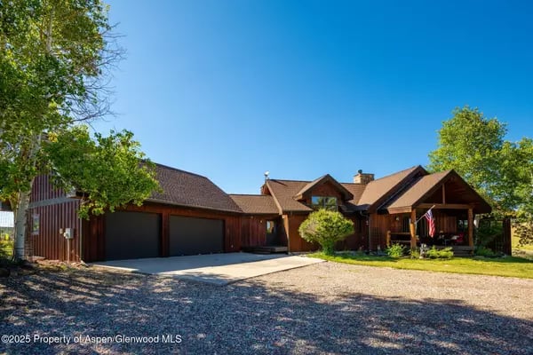 Wood-sided home with a two-car garage and covered front porch.