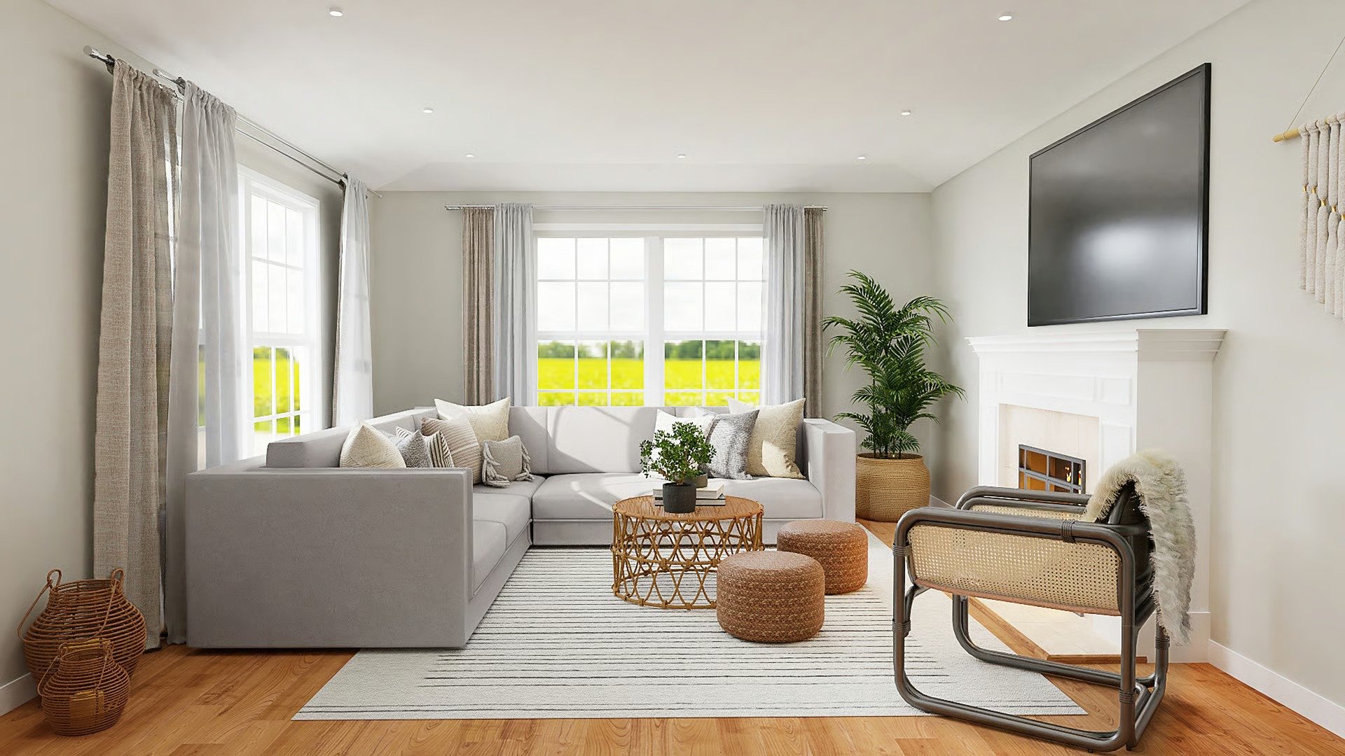 Bright living room with a gray sectional, white fireplace, and large windows overlooking green fields.