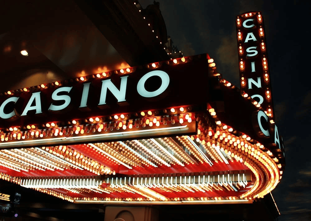 Casino marquee glowing with rows of bulbs and large CASINO lettering at night.