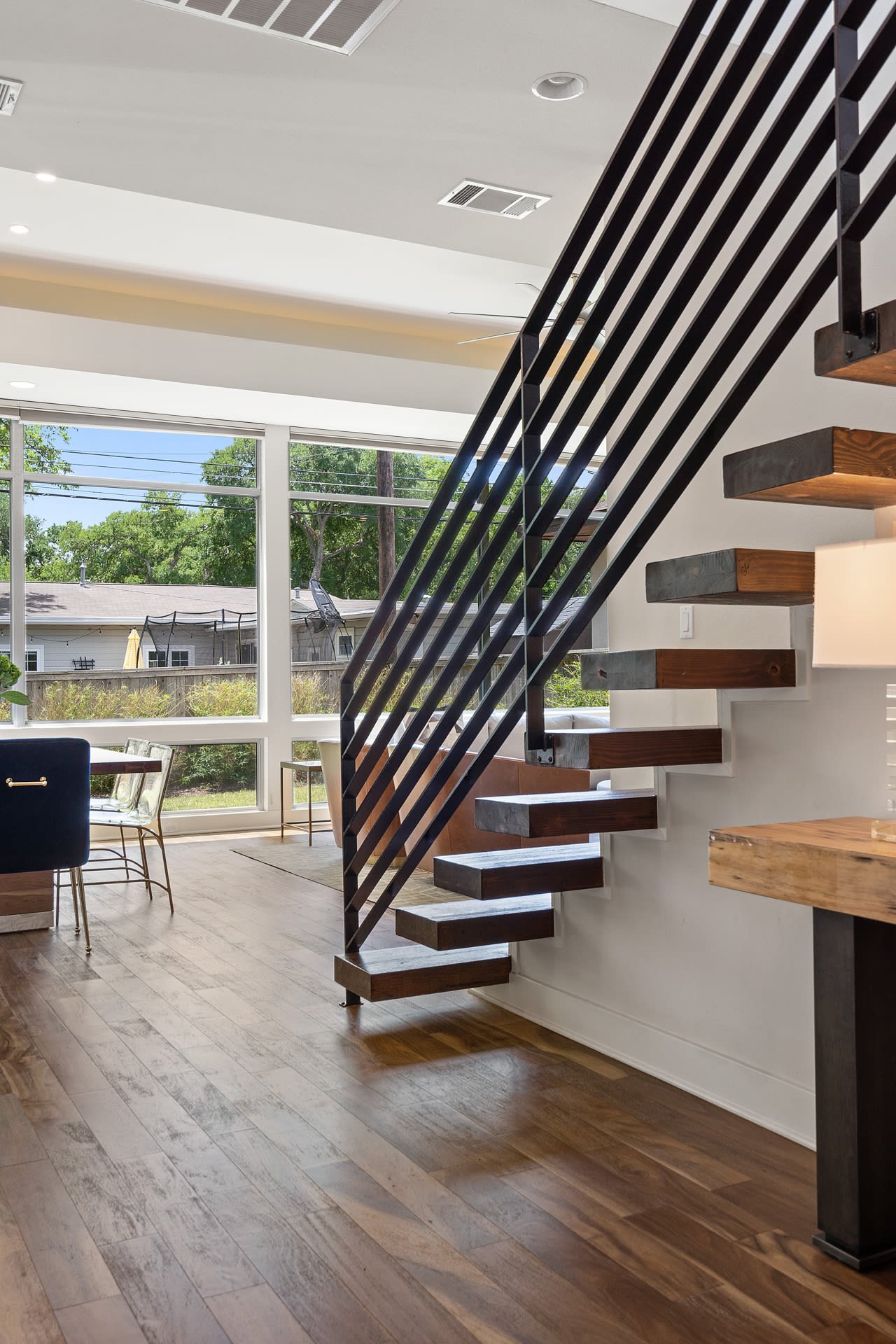 Staircase with a glass wall overlooking the dining area at 34 Margranita Crescent, Tarrytown, Austin, TX.