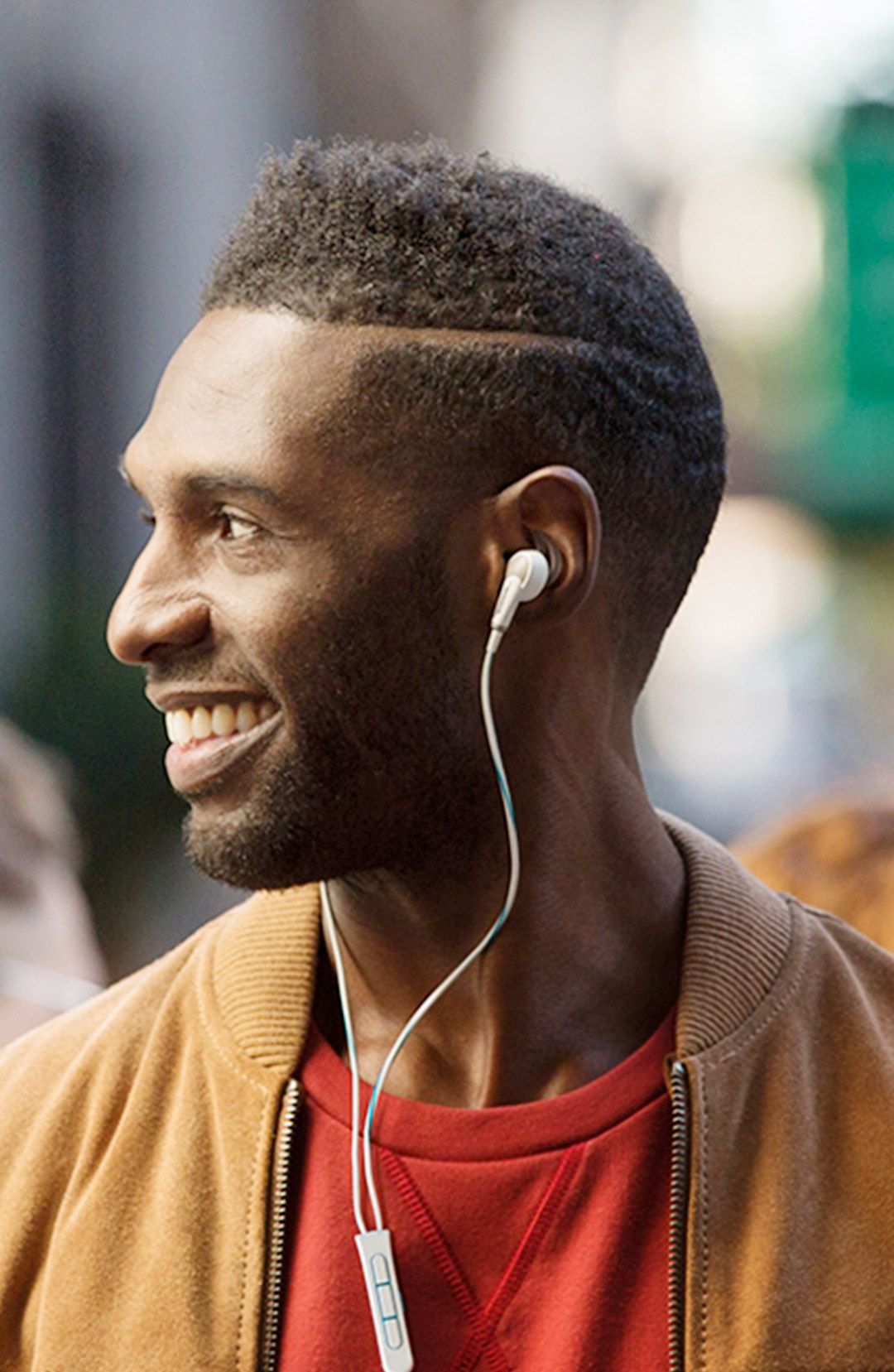 Smiling man wearing white wired earbuds