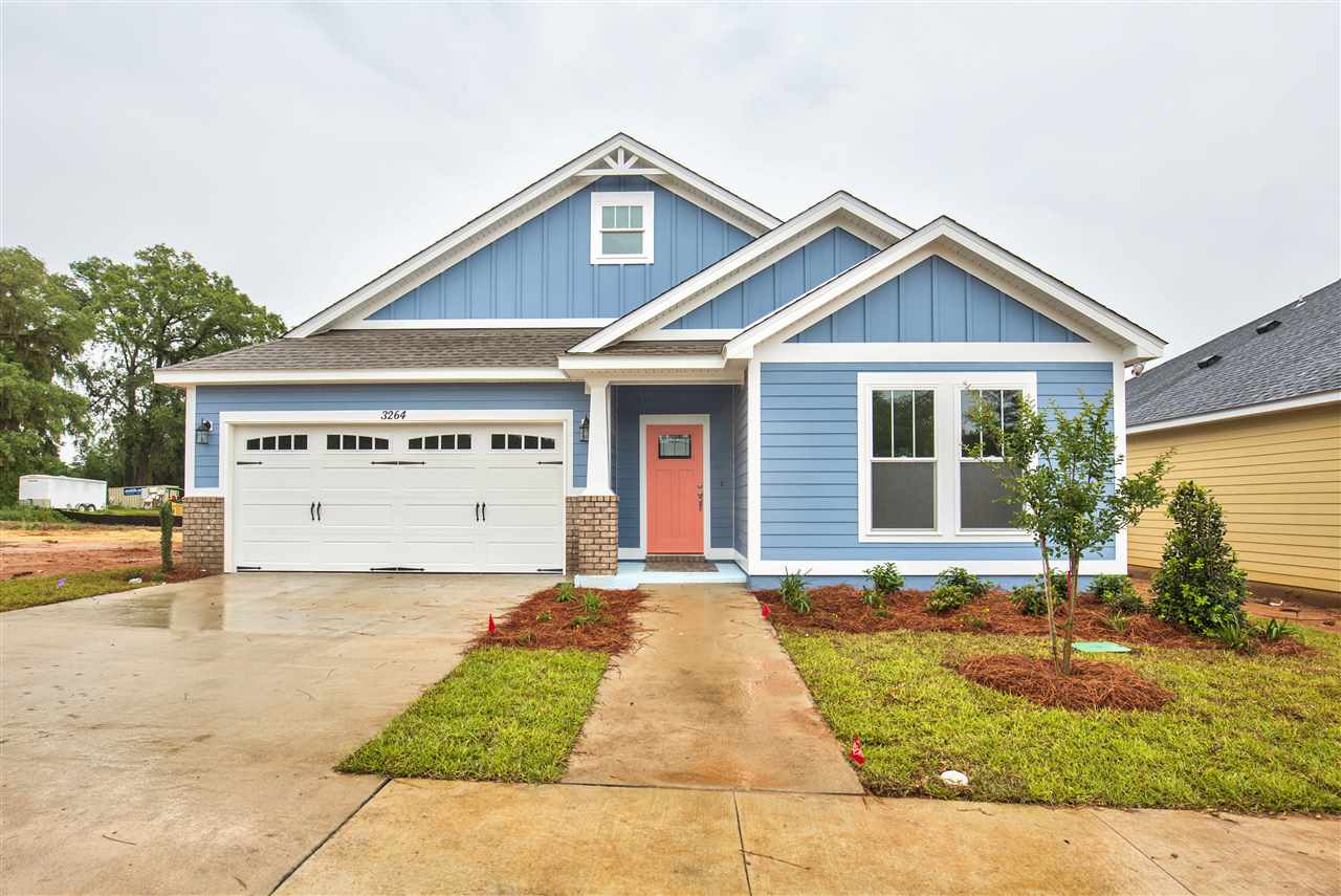 A blue house featuring a garage and a driveway, showcasing a welcoming residential environment.