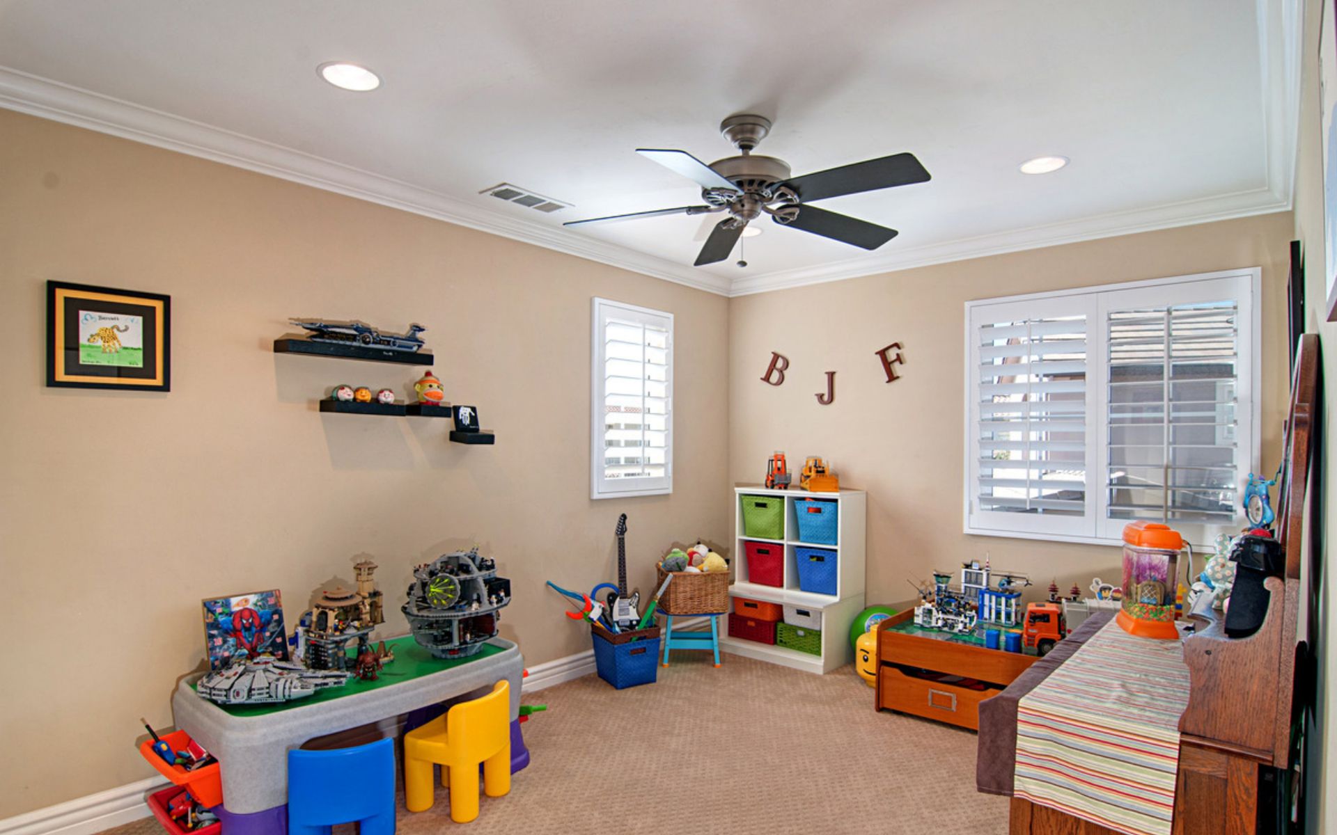 Children’s playroom with colorful toy storage, building sets, and shuttered windows.