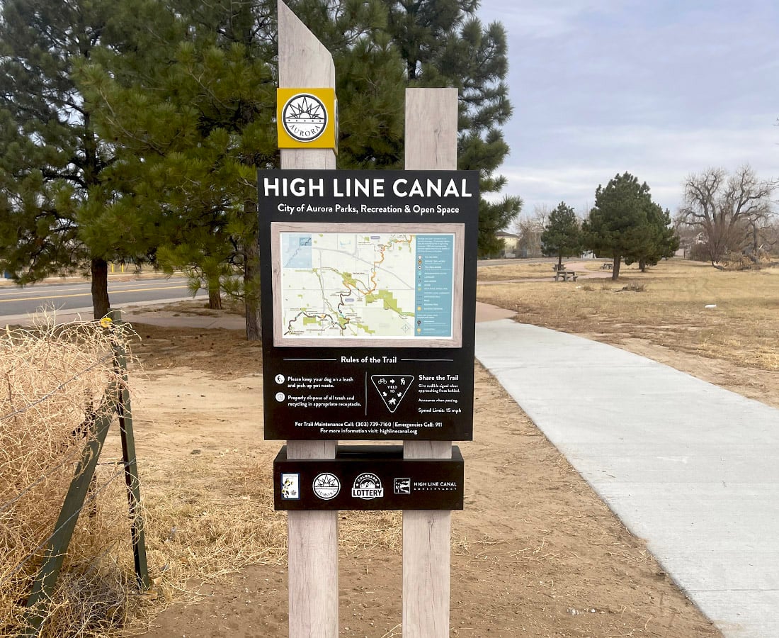 High Line Canal trail sign with a map beside a paved path in Aurora.