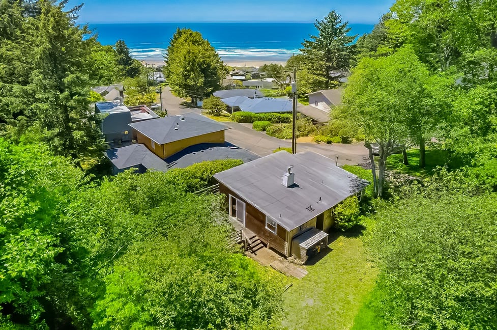 Ocean-view mid-century cabin at 8415 Treasure Rocks Road in Neahkahnie, Nehalem, Oregon, with creek frontage and wooded coastal privacy.