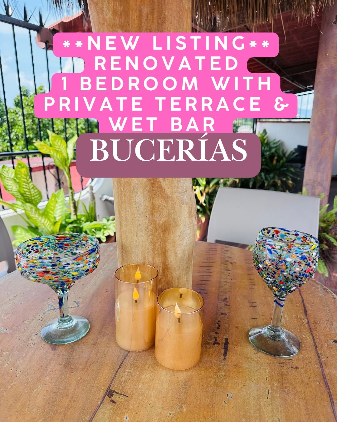 Private terrace with a wooden table, colorful glasses, candles, and tropical plants.