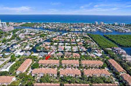 Aerial view of East Boca neighborhoods, waterways, and coastal high-rises with the ocean beyond.