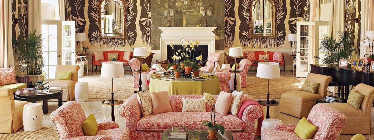 Elegant living room with a central fireplace, patterned seating, and tall windows.