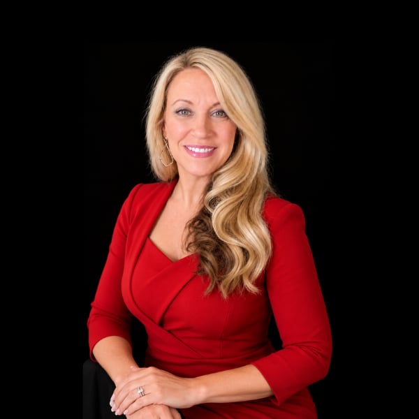 Patricia Anderson wearing a red dress, with long blonde hair.