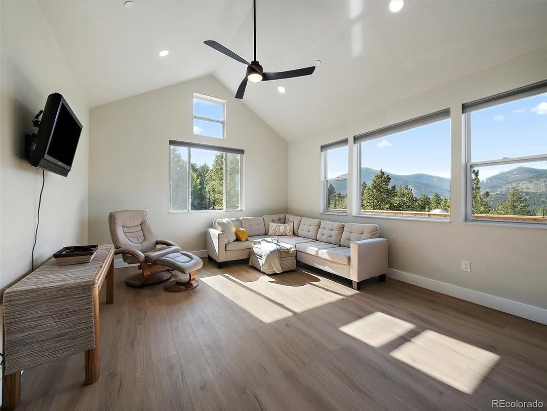 Evergreen mountain retreat at 33884 Bergen View Trail, Colorado: modern cottage nestled among pine trees on 3 private acres in Upper Bear, with big windows, outdoor living space, and long-range mountain views.