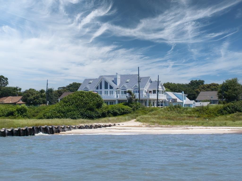 Coastal home in Townbank beside a sandy shoreline and calm water.