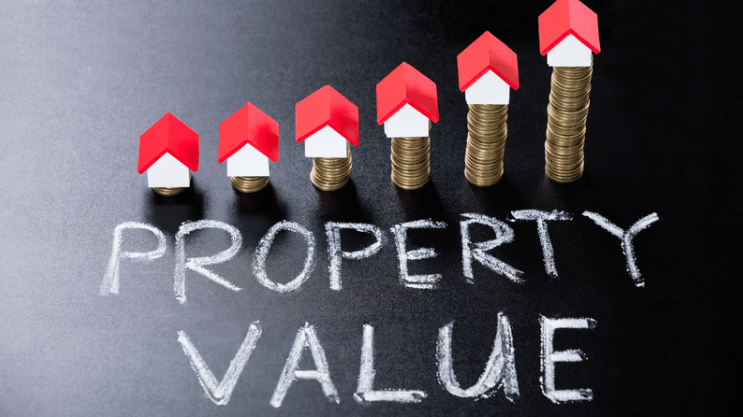 Model houses and rising coin stacks above the words “PROPERTY VALUE.”