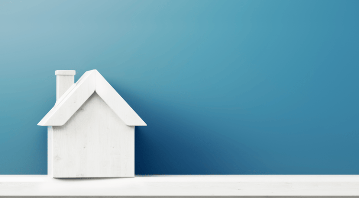 White model house with a pitched roof and chimney against a blue background