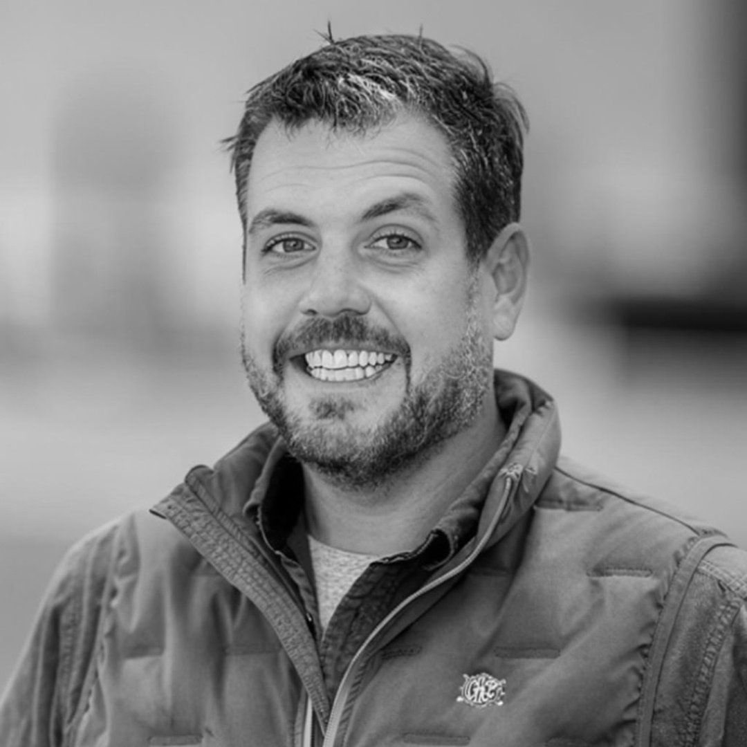Chris Gallagher smiling in a black-and-white headshot.
