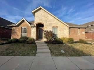 Single-story stone-and-brick home with an arched entry and concrete front walkway.
