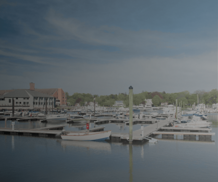 Marina with boats and rows of docks beside a waterfront building.