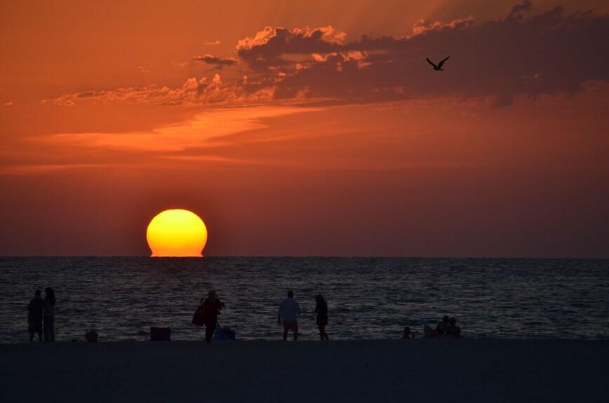 Sunset over Pass-a-Grille Beach in St. Pete Beach with soft white sand and calm Gulf waters.