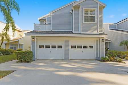 Two-story gray Fairfield home with a double garage, white trim, and palm landscaping.